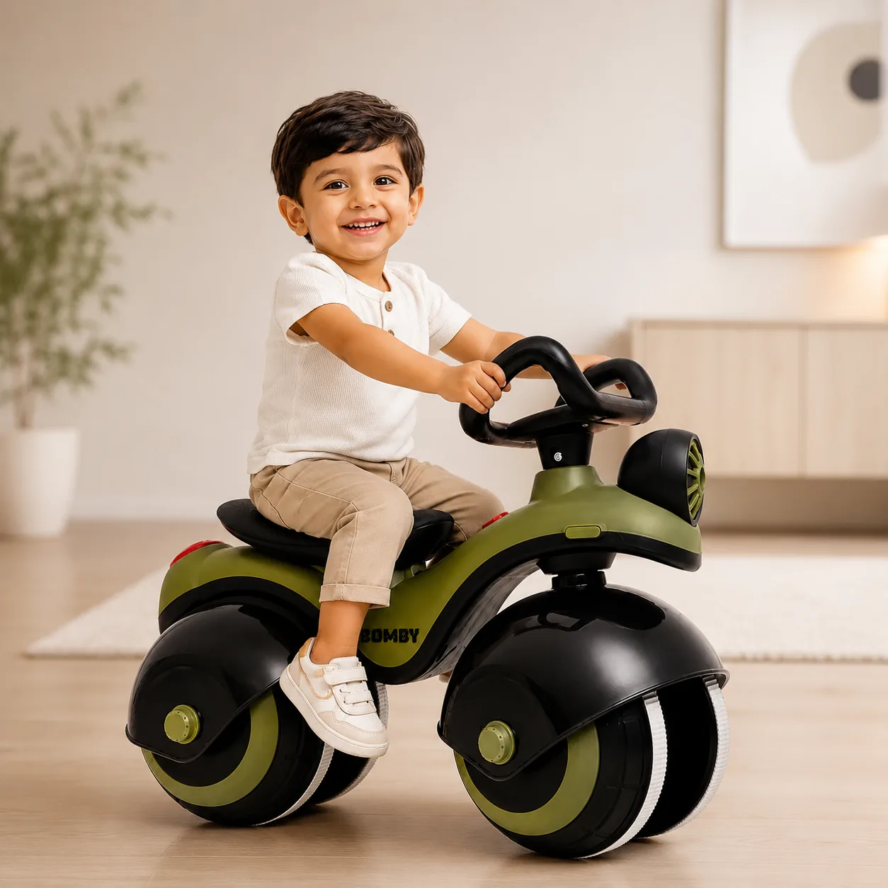 A smiling toddler riding the green Bomby in a bright living room